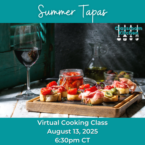 A tray sits on a table with small bits of food.  A glass of red wine sits next to the tray.  