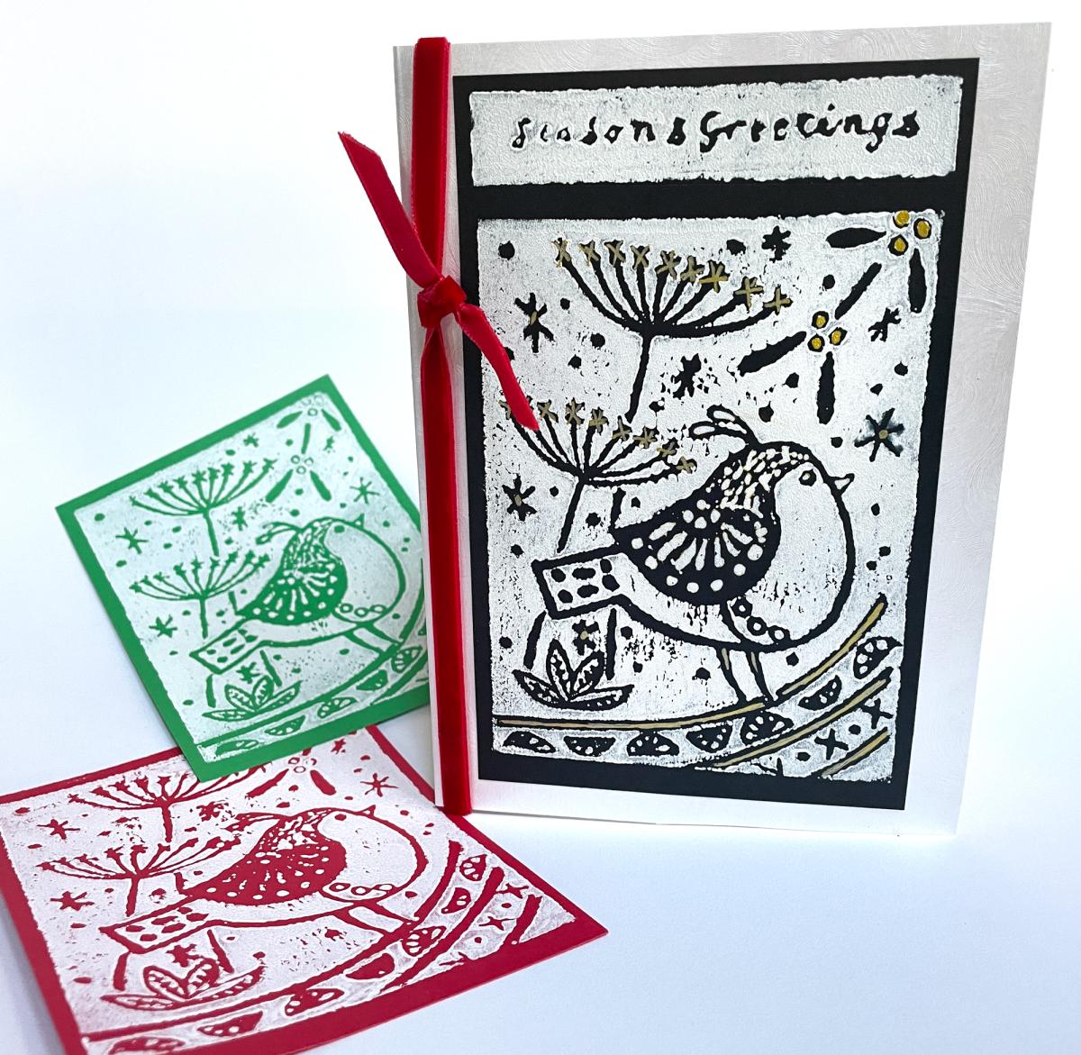 three holiday cards, red, green and black with a hand carved design